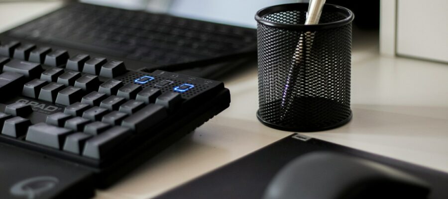 a computer keyboard and a mouse on a desk